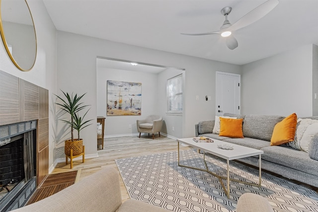 living room featuring ceiling fan and light hardwood / wood-style flooring