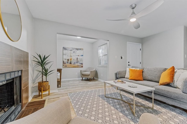 6700 Cooper Ln Unit 9, Austin, TX 78745 - living area featuring wood finished floors, a ceiling fan, and a tiled fireplace