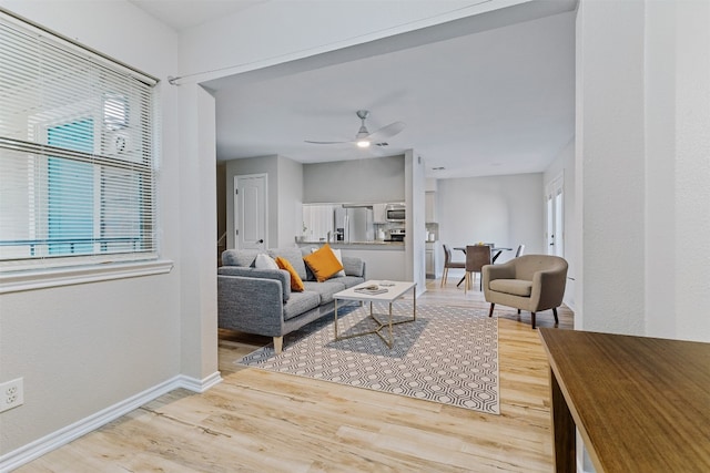 living room featuring light hardwood / wood-style floors and ceiling fan