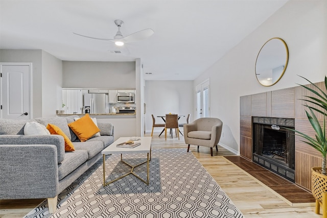 living room with light wood-type flooring and ceiling fan