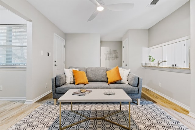 living room with ceiling fan and light wood-type flooring