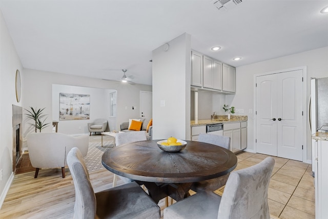 dining space with ceiling fan and light wood-type flooring