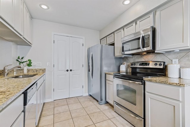 6700 Cooper Ln Unit 9, Austin, TX 78745 - kitchen with appliances with stainless steel finishes, backsplash, light tile patterned floors, light stone countertops, and recessed lighting