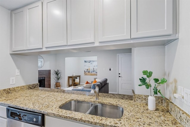 6700 Cooper Ln Unit 9, Austin, TX 78745 - kitchen with white cabinetry, light stone countertops, dishwasher, and a fireplace
