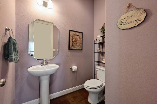 bathroom with hardwood / wood-style flooring, sink, and toilet