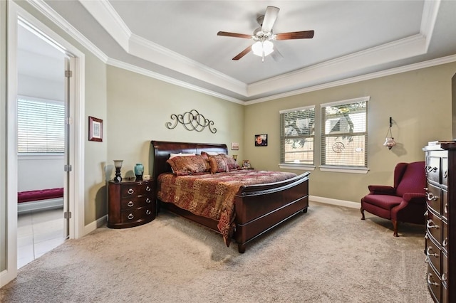 carpeted bedroom with ceiling fan, multiple windows, and a tray ceiling