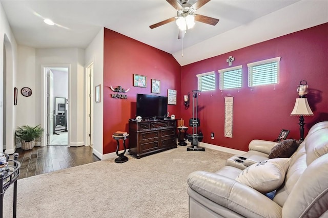 living room featuring dark hardwood / wood-style flooring, vaulted ceiling, and ceiling fan