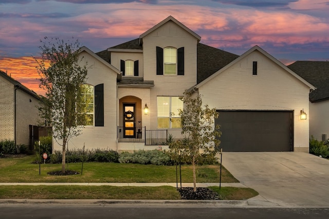 french country inspired facade featuring a porch, a garage, and a lawn