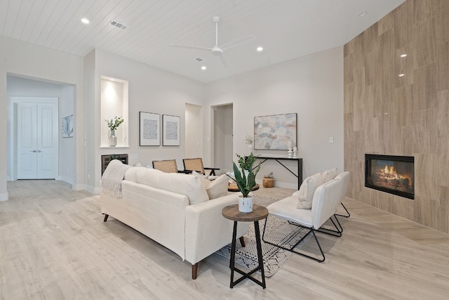 living area with recessed lighting, baseboards, light wood-style floors, and a fireplace