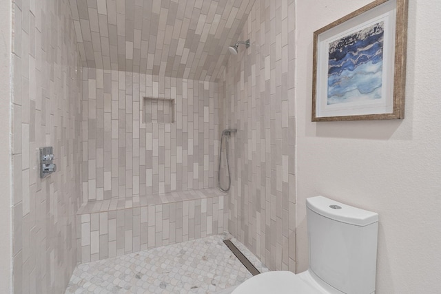 bathroom with toilet and tiled shower