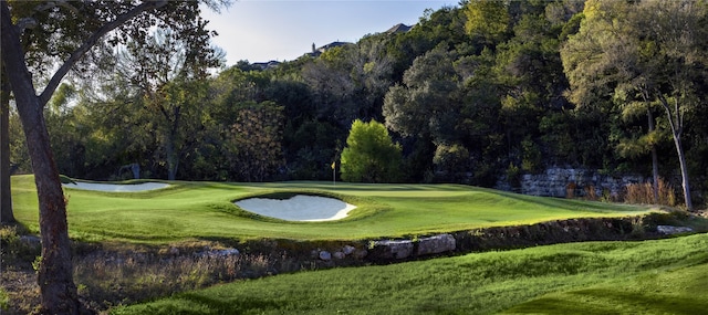 surrounding community featuring a lawn and view of golf course