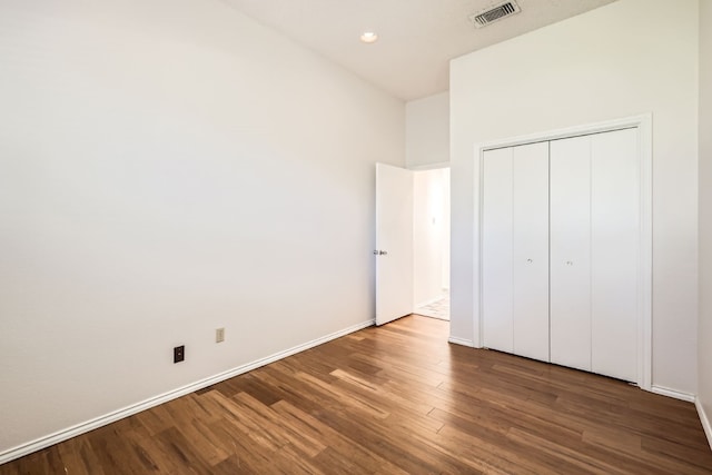 unfurnished bedroom with hardwood / wood-style flooring and a closet