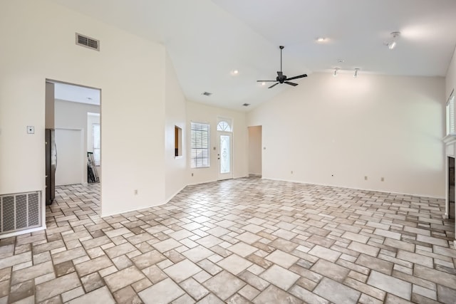 unfurnished living room with high vaulted ceiling and ceiling fan