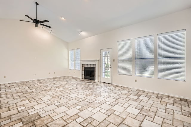 unfurnished living room featuring high vaulted ceiling, ceiling fan, and a tile fireplace