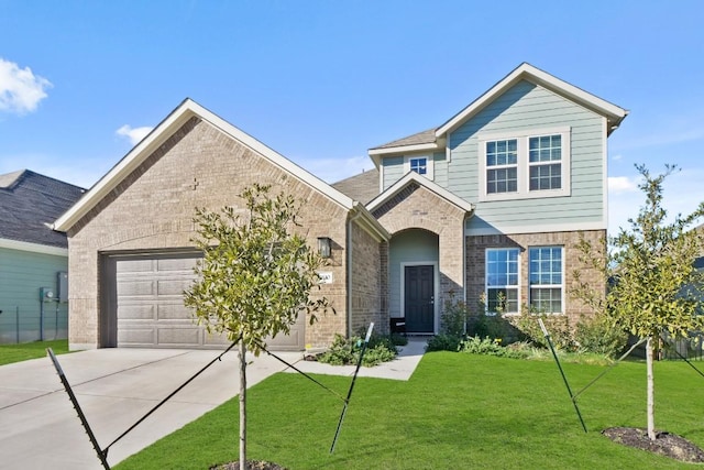 traditional home featuring a garage, a front yard, concrete driveway, and brick siding