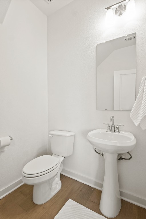 bathroom with hardwood / wood-style floors, toilet, and sink