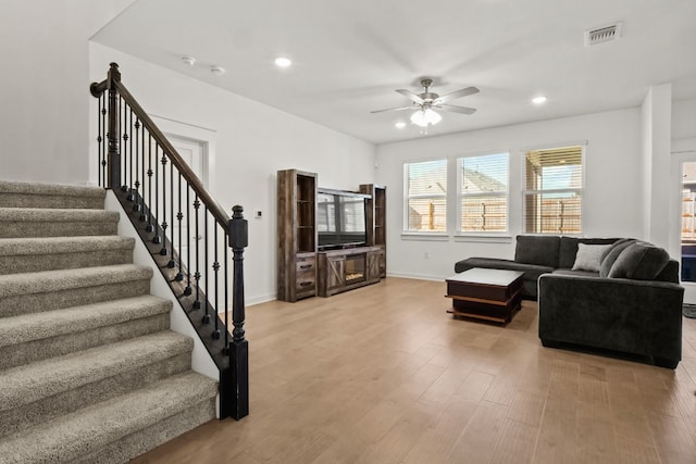 living room with light wood-type flooring and ceiling fan