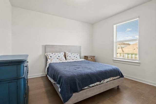 bedroom featuring baseboards and dark wood-style flooring