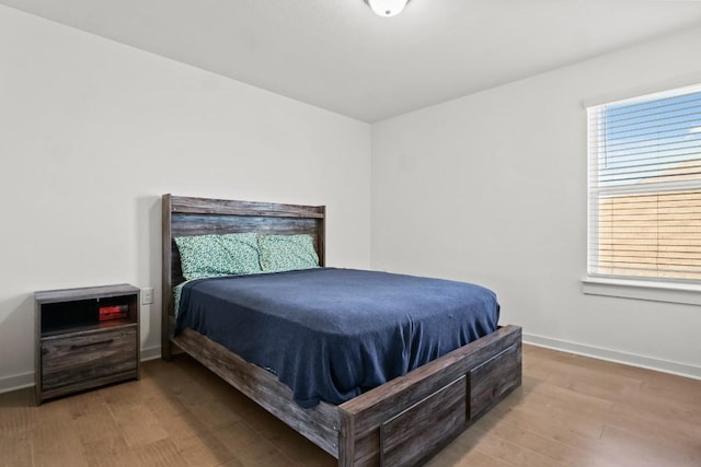 bedroom with baseboards and wood finished floors