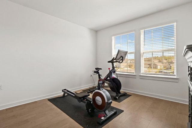 workout area with baseboards and wood finished floors