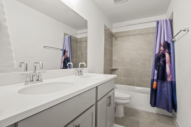 bathroom with tile patterned flooring, a sink, double vanity, and shower / tub combo