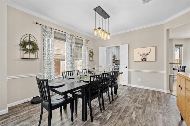 dining area featuring a chandelier, ornamental molding, and dark wood-type flooring