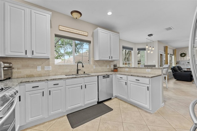 kitchen featuring a healthy amount of sunlight, sink, white cabinets, and stainless steel appliances