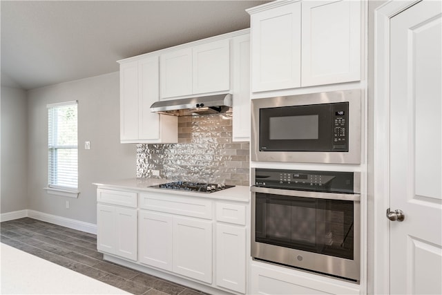 kitchen with white cabinetry, tasteful backsplash, dark hardwood / wood-style flooring, range hood, and black appliances