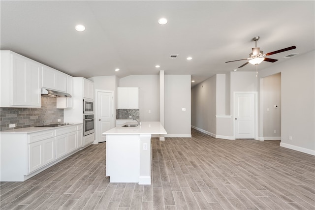 kitchen with white cabinetry, a center island with sink, light wood-type flooring, and appliances with stainless steel finishes