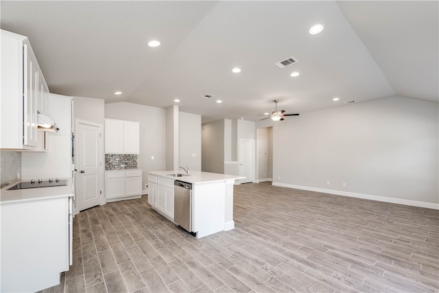 kitchen with light wood-type flooring, a center island with sink, stainless steel dishwasher, and vaulted ceiling