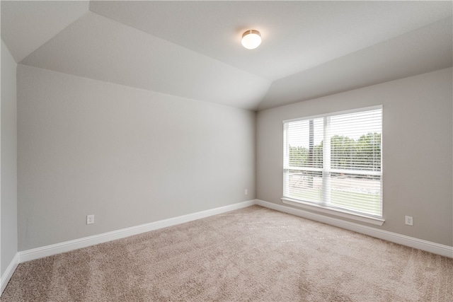 carpeted spare room featuring lofted ceiling