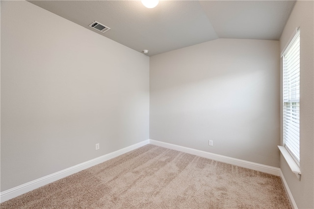 carpeted spare room featuring lofted ceiling