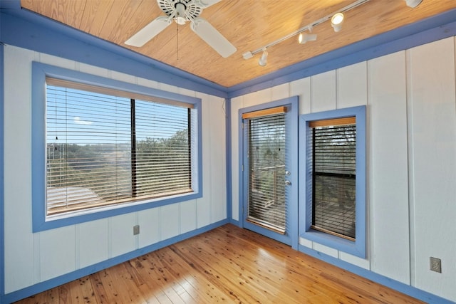 spare room with wood-type flooring, rail lighting, ceiling fan, and wood ceiling