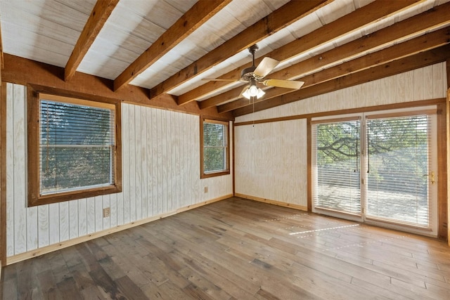 spare room with wooden ceiling, lofted ceiling with beams, wooden walls, hardwood / wood-style flooring, and ceiling fan