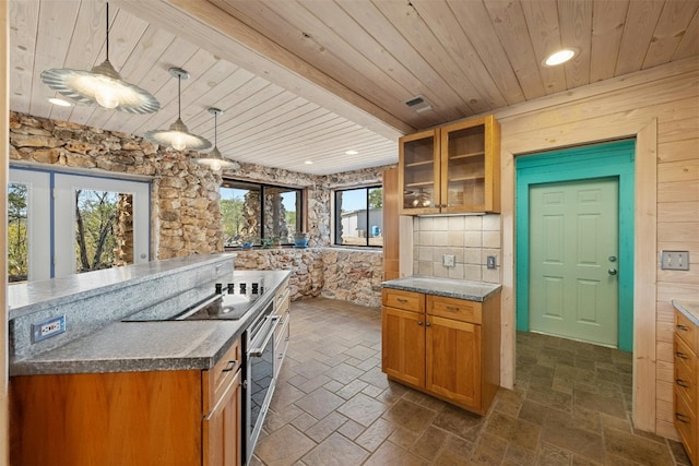 kitchen with wood ceiling, a healthy amount of sunlight, hanging light fixtures, and wood walls