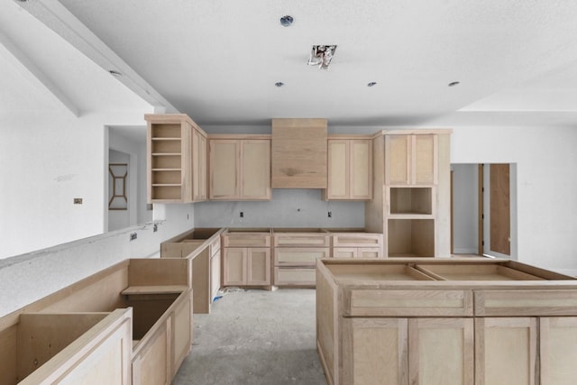 kitchen with light brown cabinetry and a textured ceiling