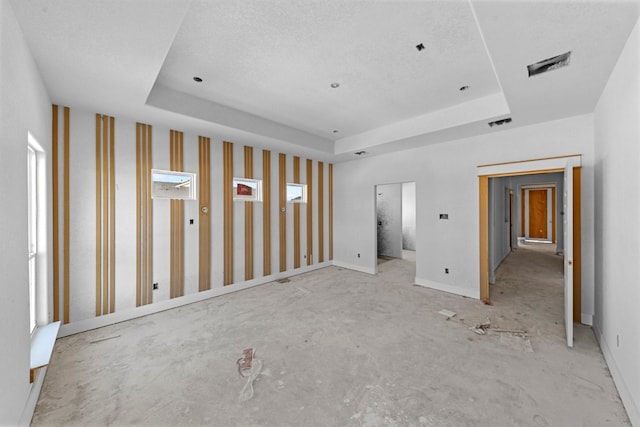 unfurnished room with a textured ceiling and a tray ceiling