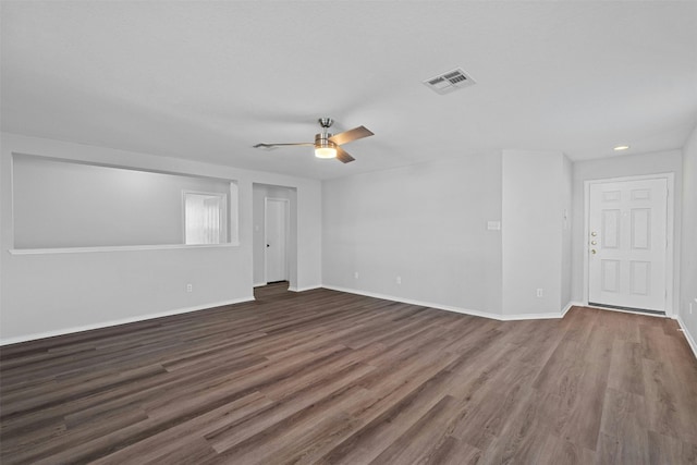 unfurnished room with baseboards, visible vents, ceiling fan, and dark wood-type flooring