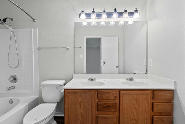 bathroom featuring toilet, double vanity, a sink, and shower / bathing tub combination