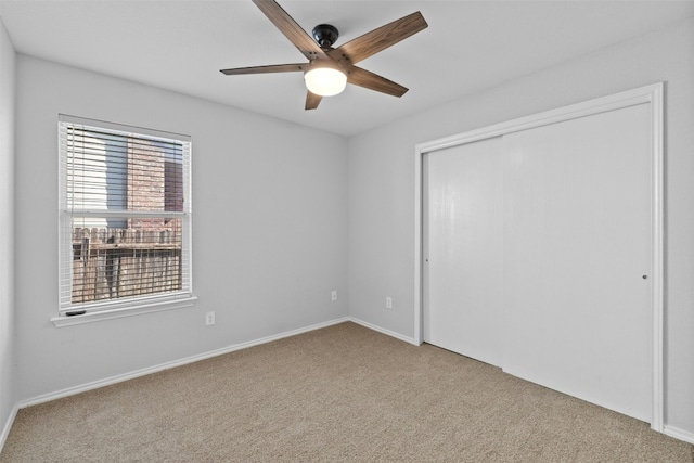 unfurnished bedroom featuring ceiling fan, a closet, and carpet