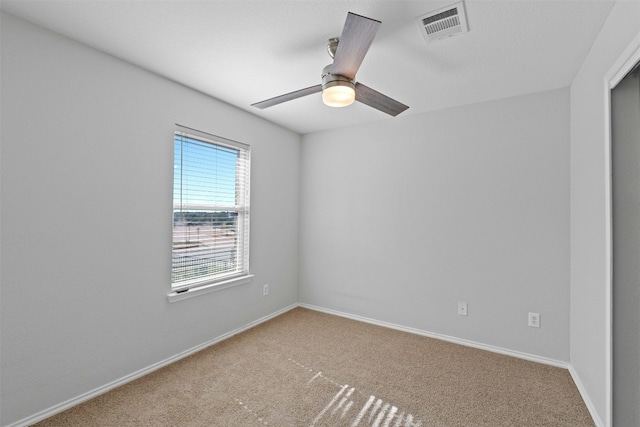 spare room with baseboards, ceiling fan, visible vents, and carpet flooring