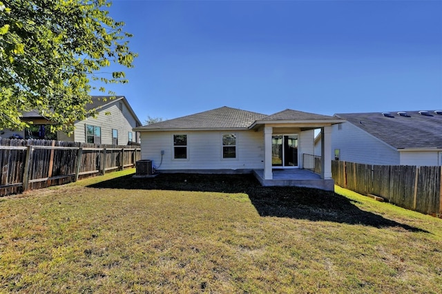 rear view of property featuring a fenced backyard, a lawn, central AC, and a patio