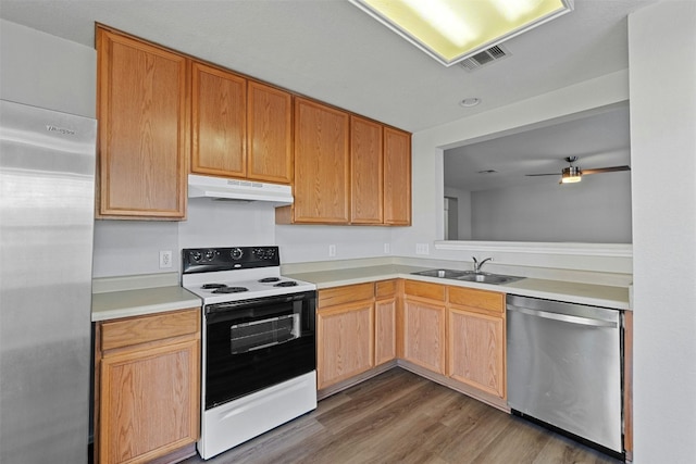 kitchen featuring under cabinet range hood, stainless steel appliances, a sink, visible vents, and light countertops