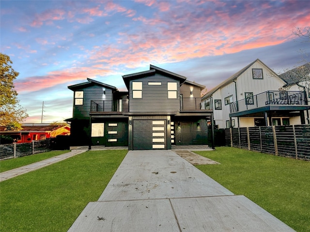 view of front of home with a lawn, a balcony, and a garage