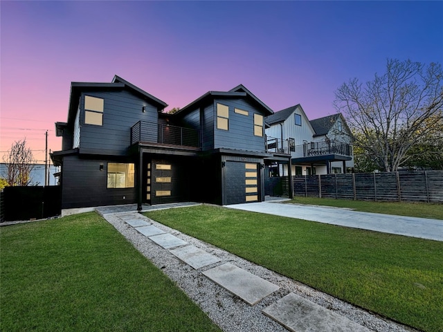 view of front facade with a lawn, a garage, and a balcony