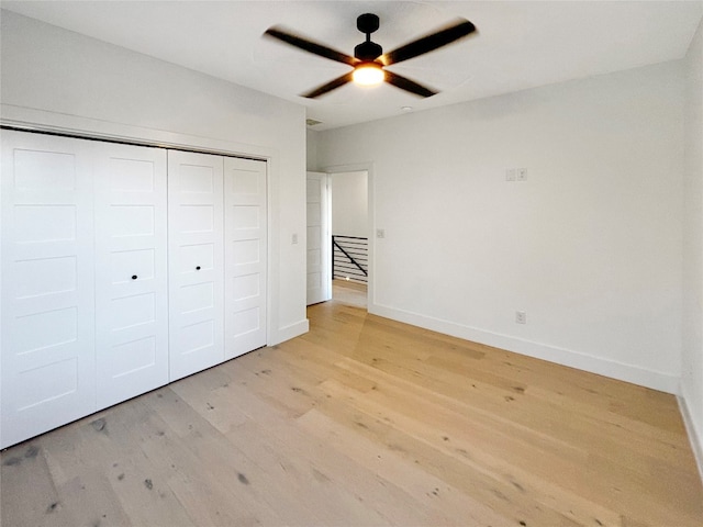 unfurnished bedroom featuring ceiling fan, a closet, and light hardwood / wood-style floors