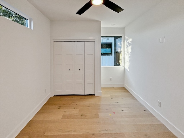 unfurnished bedroom featuring ceiling fan, light wood-type flooring, and a closet