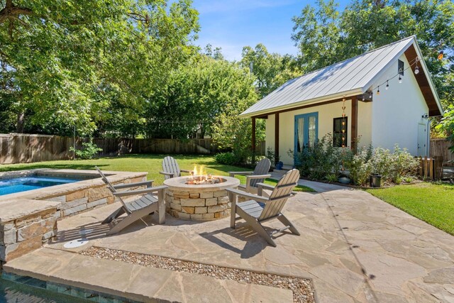 view of patio with a fire pit and an outdoor structure