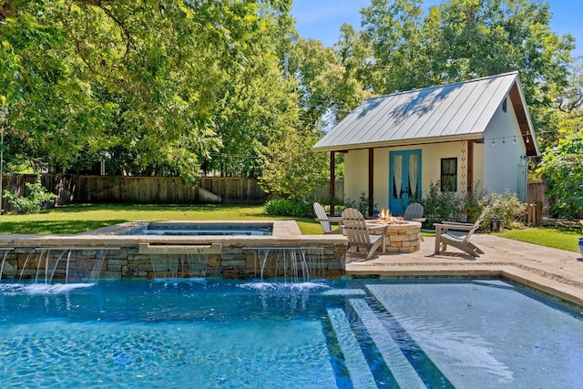 view of swimming pool with a fire pit, a patio, an outdoor structure, pool water feature, and an in ground hot tub