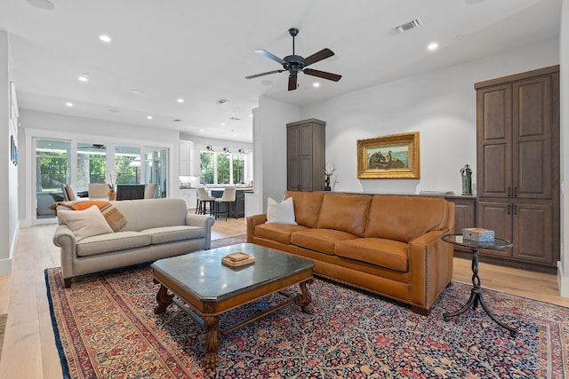 living room featuring light hardwood / wood-style floors and ceiling fan